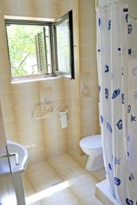 a bathroom with a toilet and a shower curtain at Apartments Villa Zvonimir in Slatine +31 photos