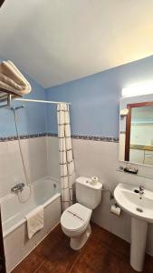 a bathroom with a white toilet and a sink at HOSTAL ALBE in Carrión de los Condes