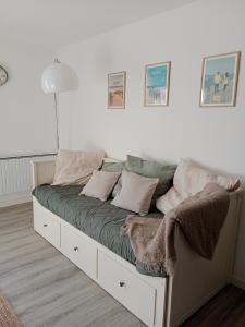 una cama con almohadas en una habitación en La Salicorne, maison d'hôtes., en Brévands