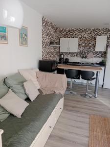 ein Sofa im Wohnzimmer mit einem Schreibtisch in der Unterkunft La Salicorne, maison d'hôtes. in Brévands