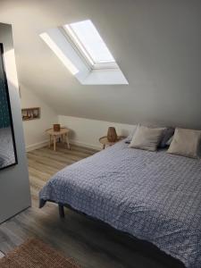 um quarto com uma cama grande e uma clarabóia em La Salicorne, maison d'hôtes. em Brévands