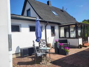een patio met een tafel en een parasol bij Haus am Wald - Haus Nils und Haus Nele in Bark