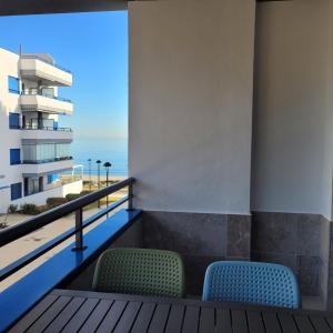 a balcony with two chairs and a view of the ocean at Apartamento Castillo Bajo in Torrox Costa