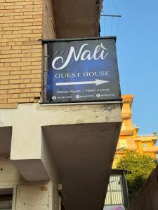 un letrero para una casa de huéspedes al lado de un edificio en Nalí Guest House, en Ercolano