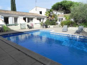 una grande piscina blu di fronte a una casa di VILLA DEL RE 7 dans Résidence avec piscine a La Flotte