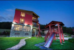una casa con scivolo e parco giochi di fronte di RED HOUSE a Bakuriani