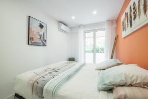 a bedroom with a large bed with an orange wall at Charmant 2 pièces - Proche plage in Menton