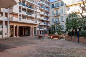 un patio frente a un gran edificio de apartamentos en Charmant 2 pièces - Proche plage en Menton