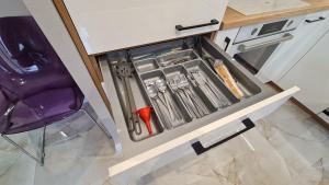 un tiroir dans une cuisine avec des ustensiles. dans l'établissement Modlin Deluxe Suite, à Nowy Dwór Mazowiecki 9 autres photos