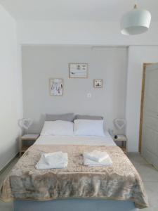 a bedroom with a bed with two towels on it at IOKASTI STUDIO 1 in Andros