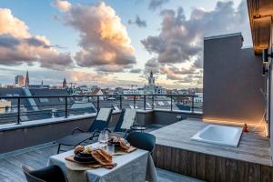 een balkon met een tafel en stoelen met uitzicht op een stad bij Love Nest - Your cosy penthouse in Oostende