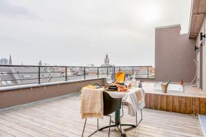 una mesa en la parte superior de un balcón con vistas en Love Nest - Your cosy penthouse en Ostende