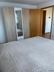 Ferienwohnung في Emmingen-Liptingen: غرفة نوم بسرير كبير ومرآة