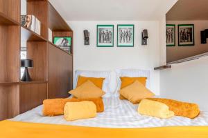 1 dormitorio con 1 cama grande con almohadas de color naranja en Love Nest - Your cosy penthouse en Ostende