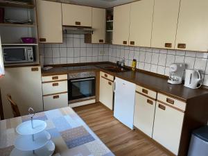 uma cozinha com armários brancos e uma bancada em Ferienwohnung em Emmingen-Liptingen