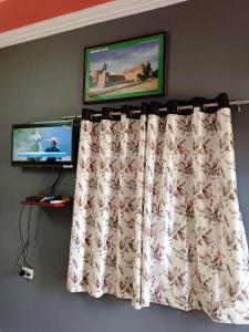 a curtain on a wall with a tv in a room at Hotel Yuvraj Nature and Restaurant in Pushkar