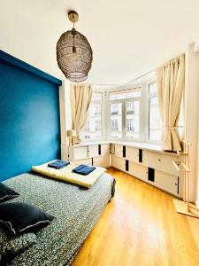 a bedroom with a bed and a blue wall at Central Luxury Louvre Opera 3rd Floor in Paris