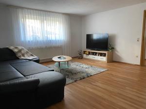 uma sala de estar com um sofá e uma televisão de ecrã plano em Ferienwohnung em Emmingen-Liptingen