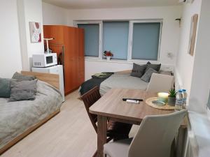 uma sala de estar com uma mesa, uma cama e um sofá em Болярска10 em Burgas