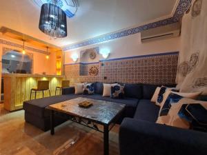 - un salon avec un canapé bleu et une table dans l'établissement Casa Amine, à Chefchaouen
