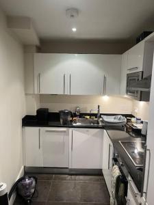 a kitchen with white cabinets and a sink at 1 Bed flat in Central London in London
