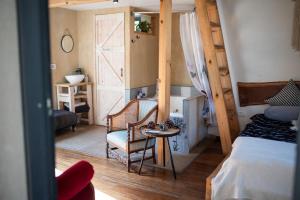 1 dormitorio con 1 cama, 1 silla y 1 mesa en Gate Away B&B Units - המקום באל רום en El-Rom