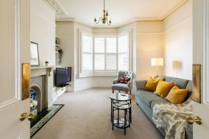 a living room with a couch and a tv at Stylish period maisonette flat in centre of Bath in Bath