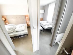 ein kleines Zimmer mit 2 Betten und einem Spiegel in der Unterkunft Soleil Levant in Berdorf