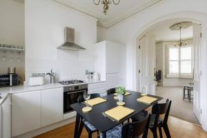 a kitchen with a table with chairs and a stove at Stylish period maisonette flat in centre of Bath in Bath +25 photos