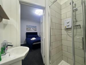 uma casa de banho com um chuveiro, um lavatório e um WC. em 4 bedroom, sleeps 8 comfy home near to City Centre and Beaches! em Swansea