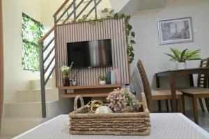 a wicker basket sitting on a table with a television at Hyacinth by Elle's Place near Dumaguete Airport in Dumaguete