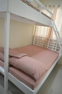 an empty bunk bed in a white room at Hyacinth by Elle's Place near Dumaguete Airport in Dumaguete
