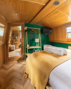 um quarto com uma cama e uma parede verde em The Four Sisters Boatel - Houseboat em Edinburgo