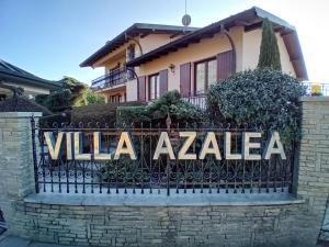 uma cerca em frente a uma casa com um sinal de vilaza em Villa Azalea em San Fermo della Battaglia