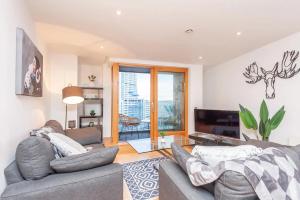 ein Wohnzimmer mit 2 Sofas und einem TV in der Unterkunft Pass the Keys Granary Wharf Deluxe - balcony and rooftop garden in Leeds