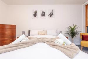 a bedroom with a white bed with a blanket on it at Pass the Keys Granary Wharf Deluxe - balcony and rooftop garden in Leeds