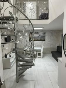 uma escada em espiral numa sala de estar com uma mesa em Mortella House em Nápoles