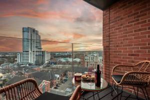 a balcony with a table with a bottle of wine at Pass the Keys Granary Wharf Deluxe - balcony and rooftop garden in Leeds