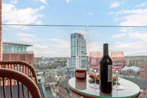 einen Tisch mit zwei Gläsern und einer Flasche Wein in der Unterkunft Pass the Keys Granary Wharf Deluxe - balcony and rooftop garden in Leeds