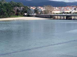 a body of water with a bridge and a beach at Luz de Mar in O Grove