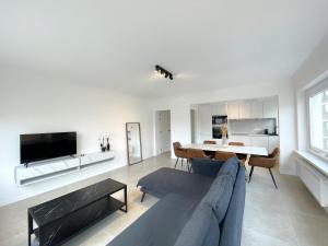 a living room with a blue couch and a table at Luxury 3 bedroom apartment on the top floor with panoramic view in Ostend