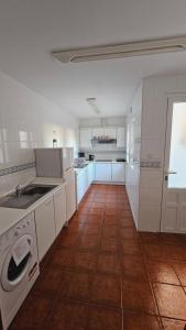 a kitchen with white cabinets and a tile floor at HOSTAL ALBE in Carrión de los Condes