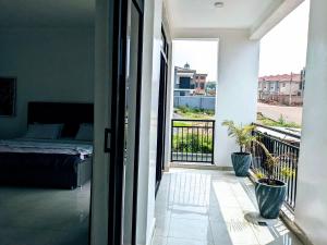 Drzwi do sypialni z łóżkiem i balkonem w obiekcie Homestay in Kigali, Rusororo w mieście Masaka