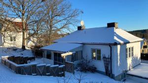 une maison blanche avec de la neige sur le toit dans l'établissement Storgatan 82 Virserum, à Virserum