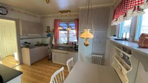 a kitchen with white cabinets and a table and chairs at Storgatan 82 Virserum in Virserum