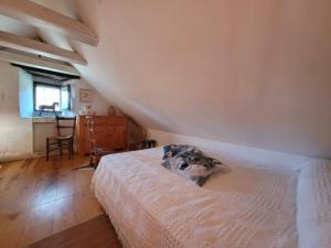 1 dormitorio con cama, mesa y ventana en L'Ostel Aveyronnais, en Golinhac