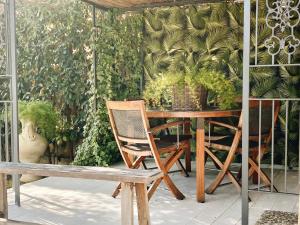 un tavolo e sedie in legno e una panca su un patio di Villa Volli Three Rooms a Agrigento