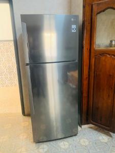 a stainless steel refrigerator next to a wooden door at Dar chenini in Gabès