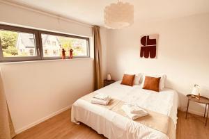 um quarto com uma cama branca e uma janela em Les terrasses de la vallée - Esneux (Liège) em Méry