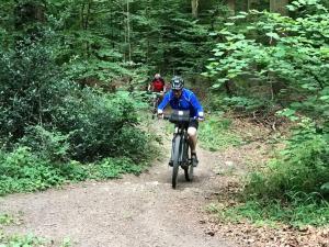 uma pessoa a andar de bicicleta num trilho de terra em Les terrasses de la vallée - Esneux (Liège) em Méry